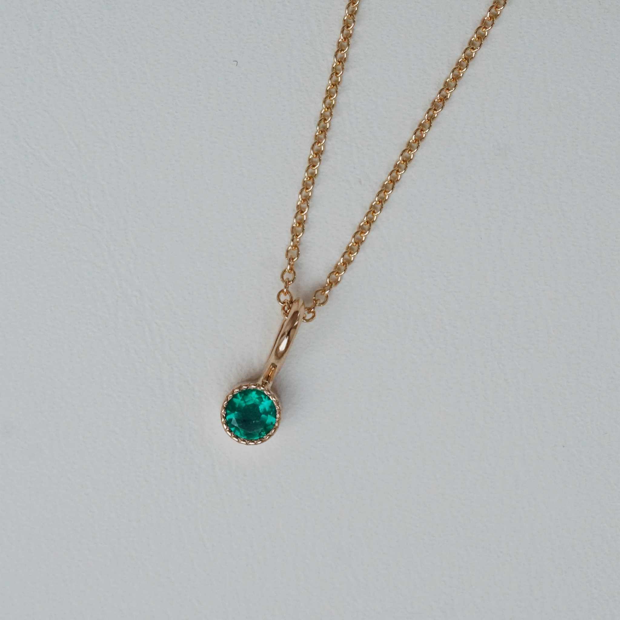 "Twinkle" pendant in gold with an emerald