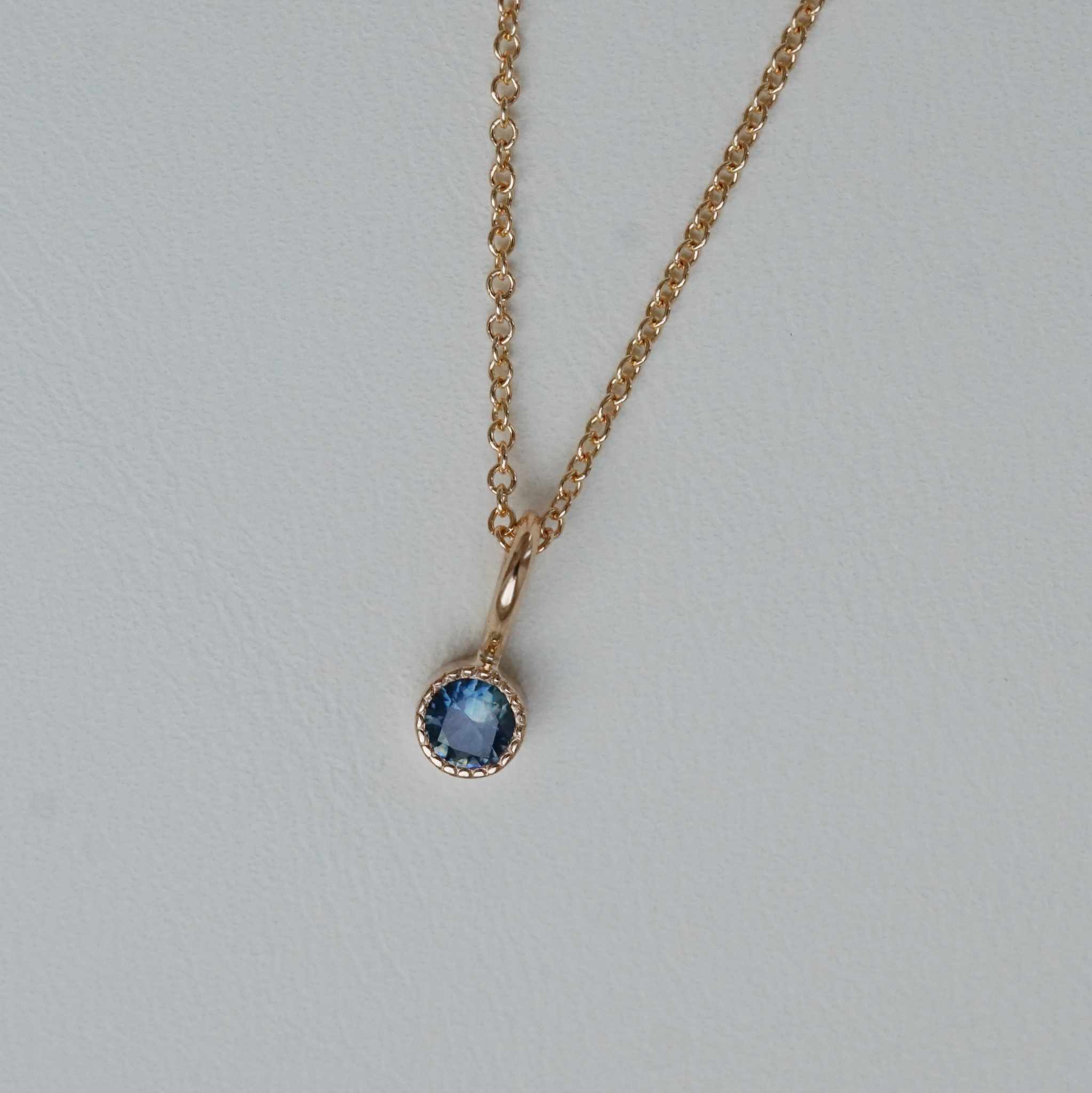 "Twinkle" pendant in gold with a teal sapphire