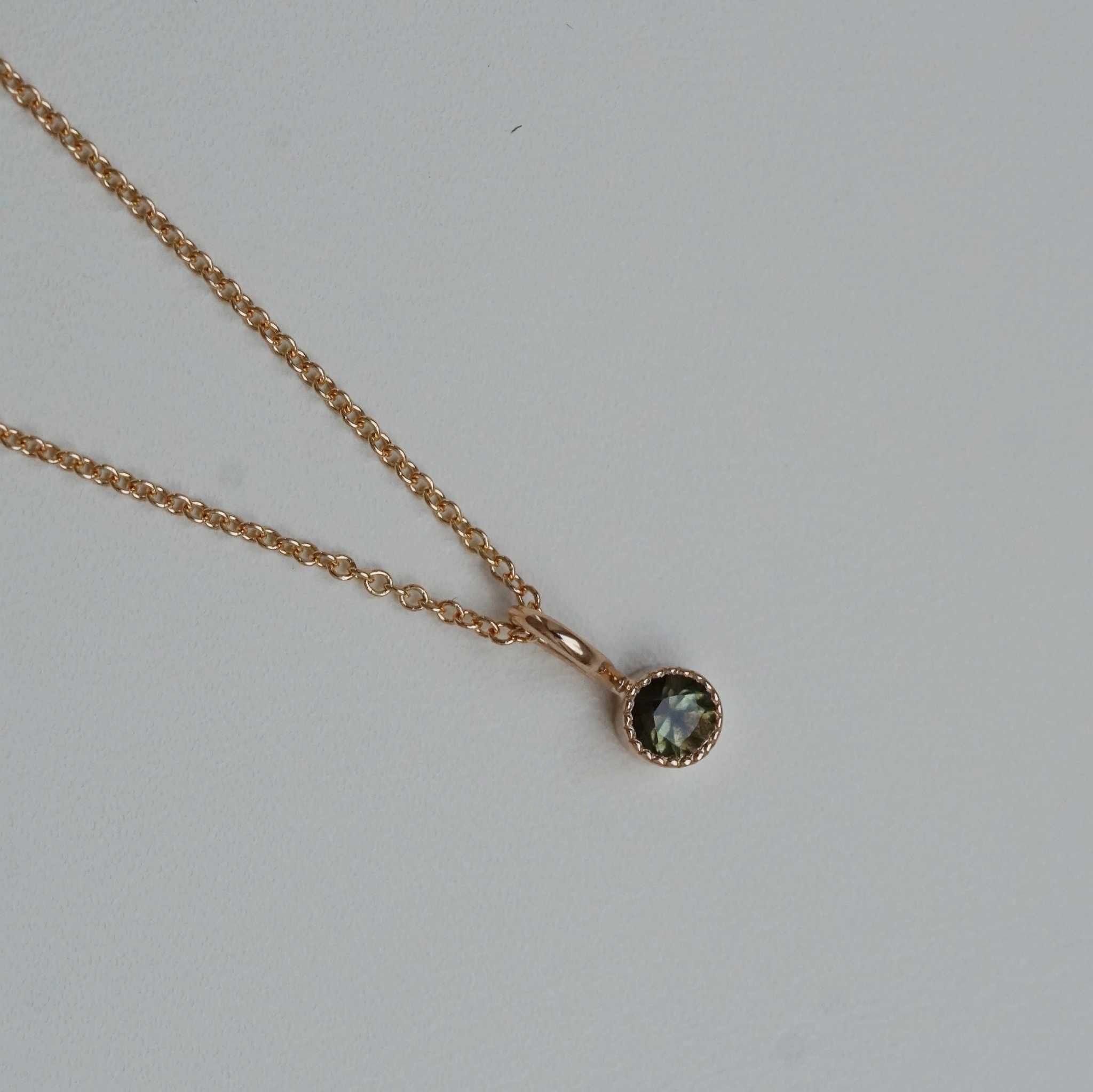 "Twinkle" pendant in gold with a greenbrown sapphire