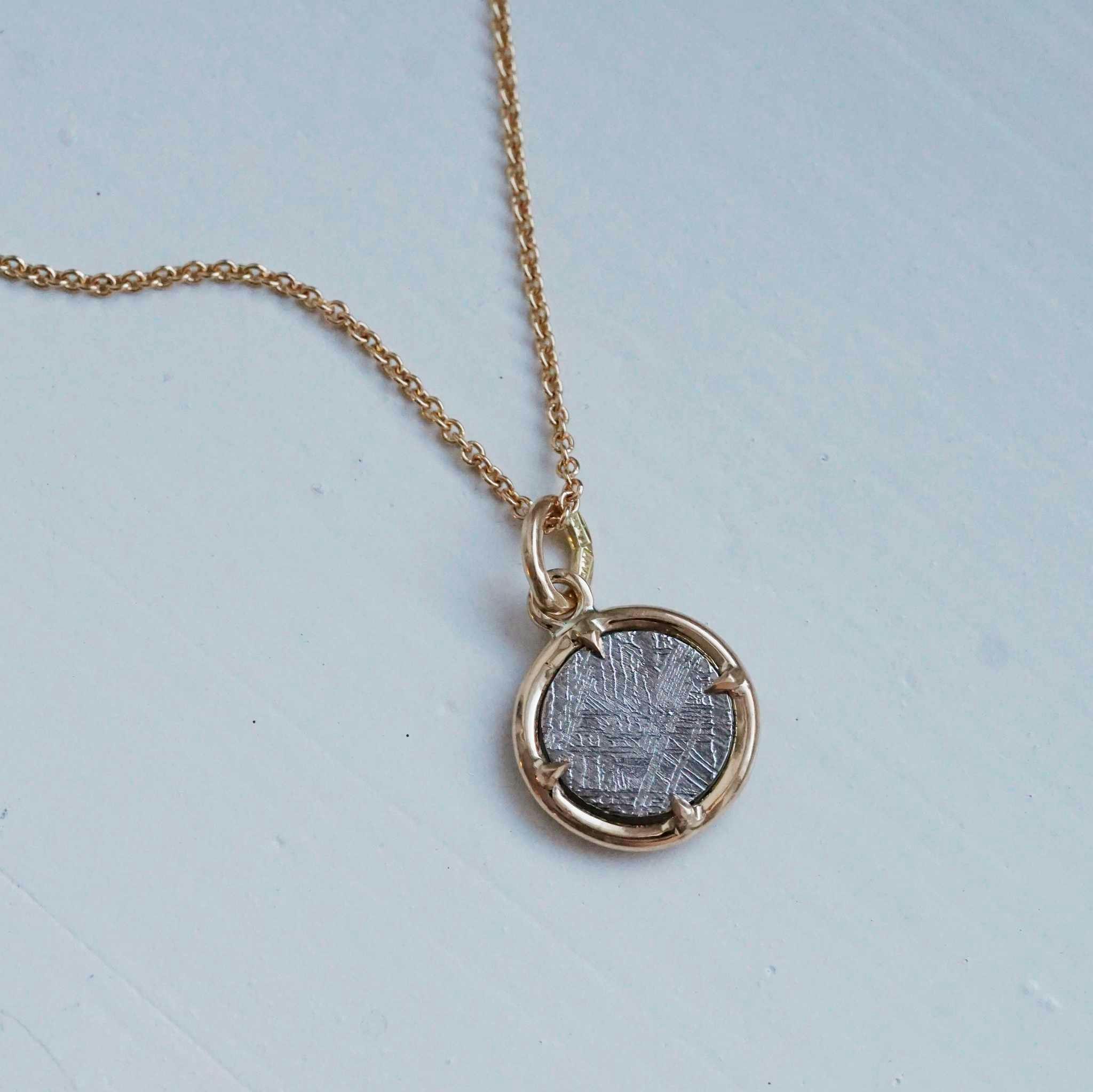 "Muonionalusta" pendant in gold with a meteorite slice