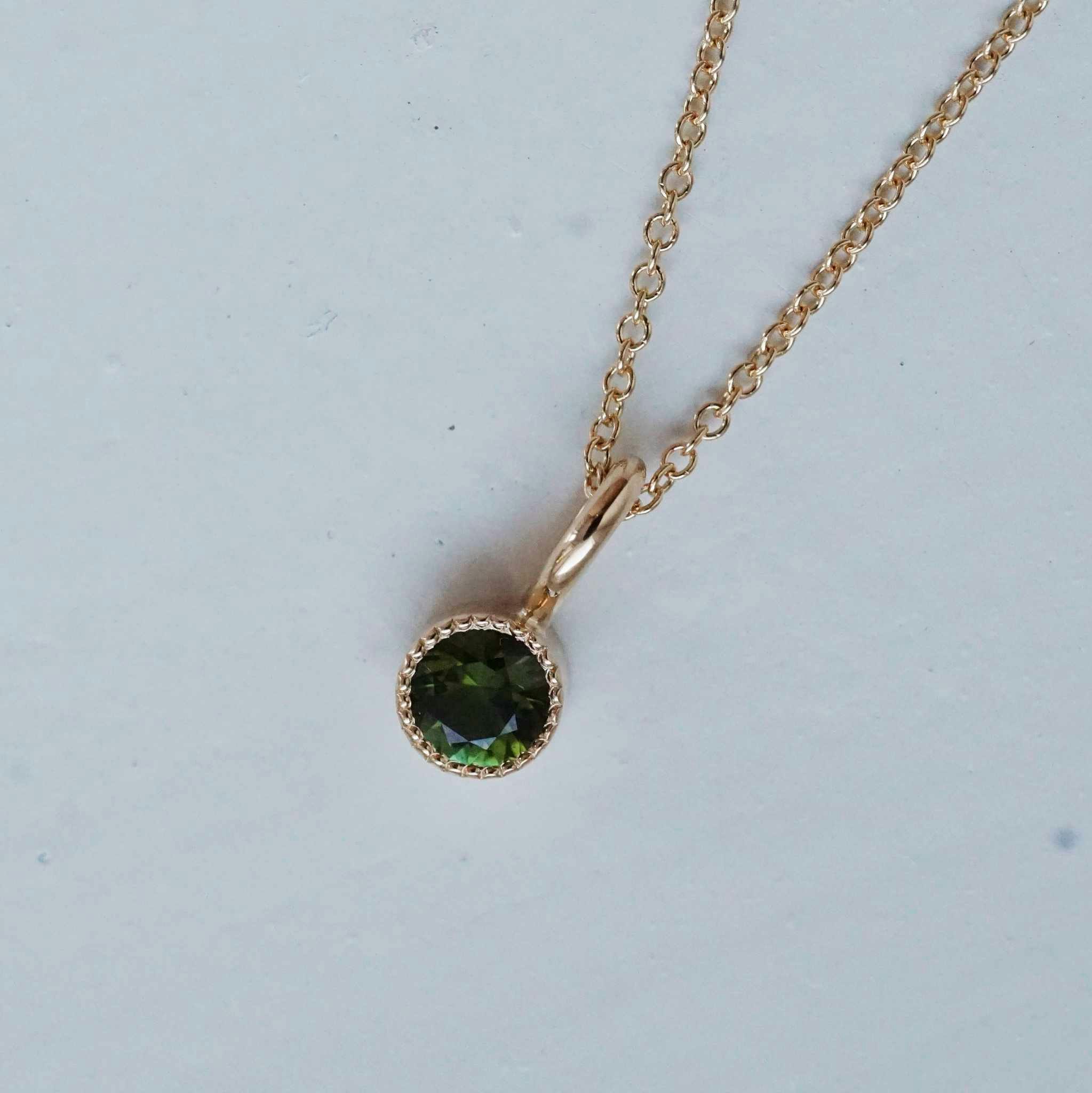 "Twinkle" pendant in gold with a dark green tourmaline