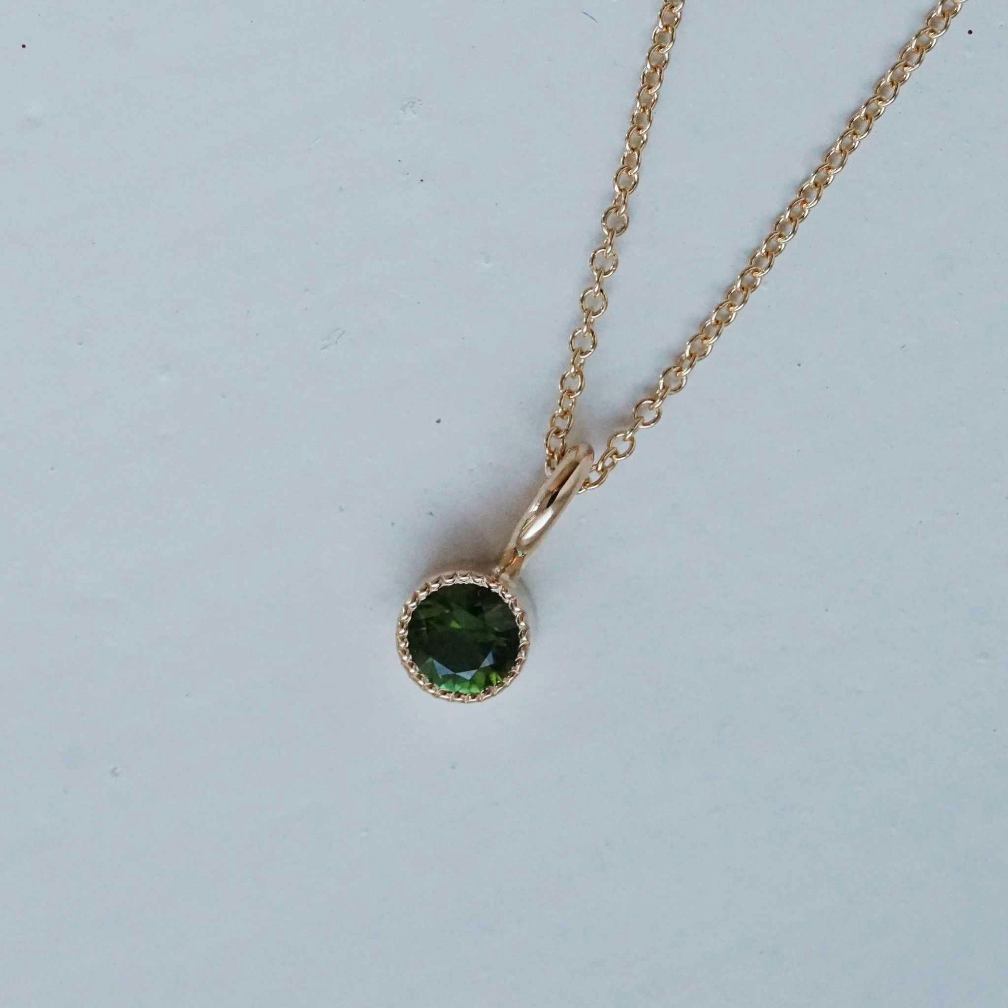 "Twinkle" pendant in gold with a dark green tourmaline