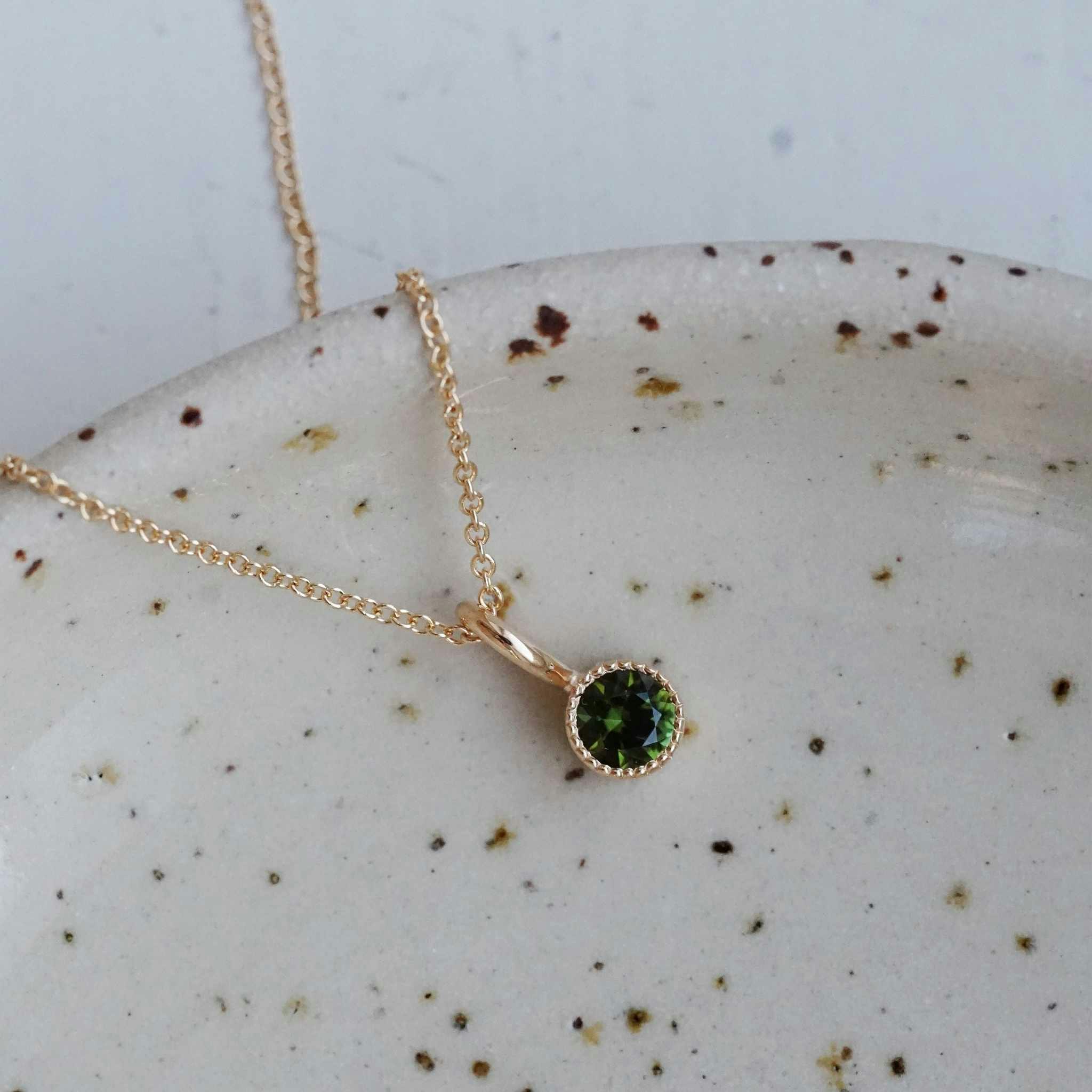 "Twinkle" pendant in gold with a dark green tourmaline