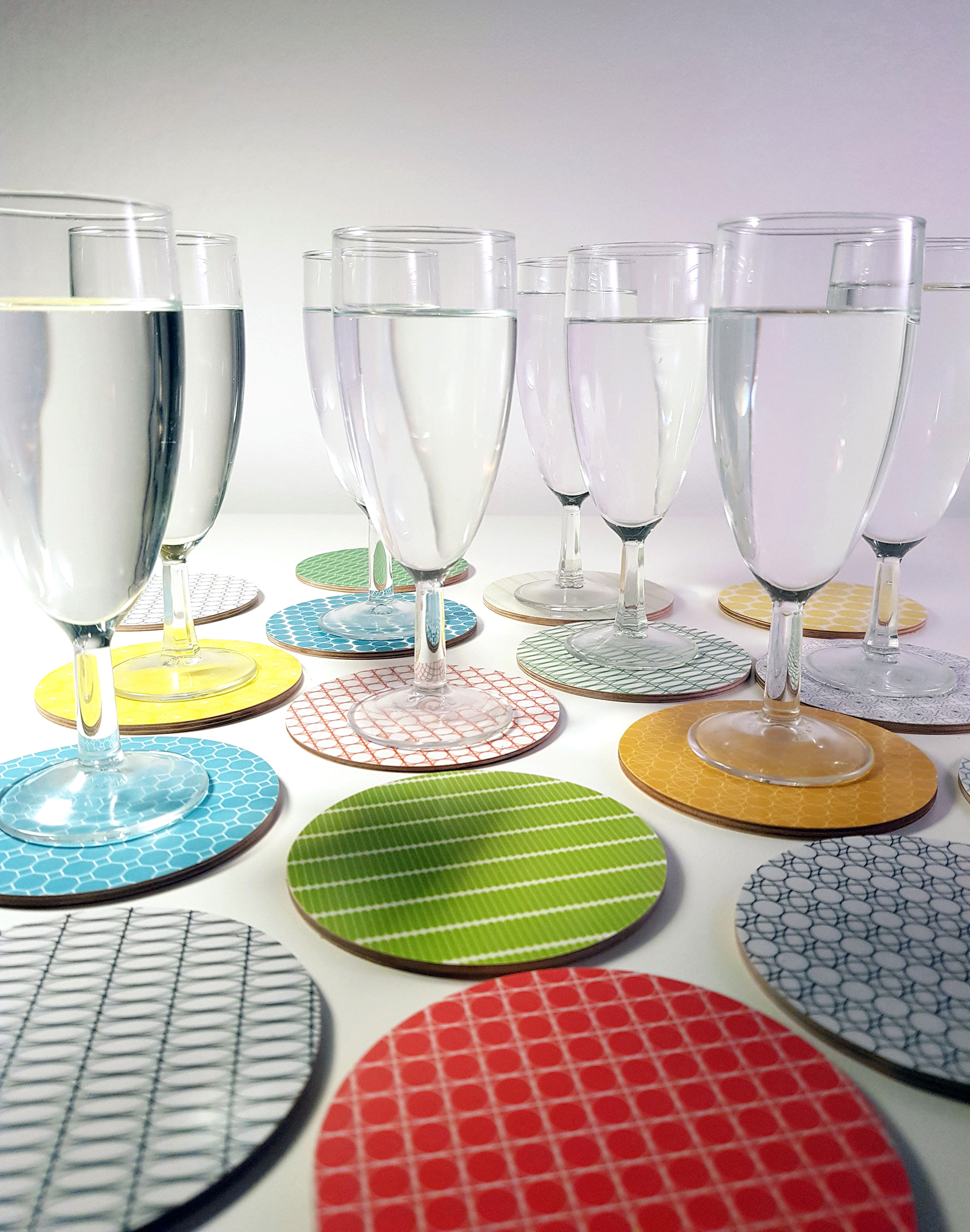 Glasunderlägg i olika färger och mönster, en för varje familjemedlem och gäst.