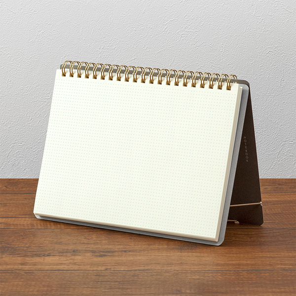 Midori + Stand Notebook [A5] Cross Grid uppställd på ett bord