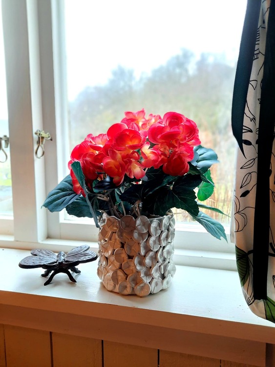 Blomkruka med blommor i kökets fönster.